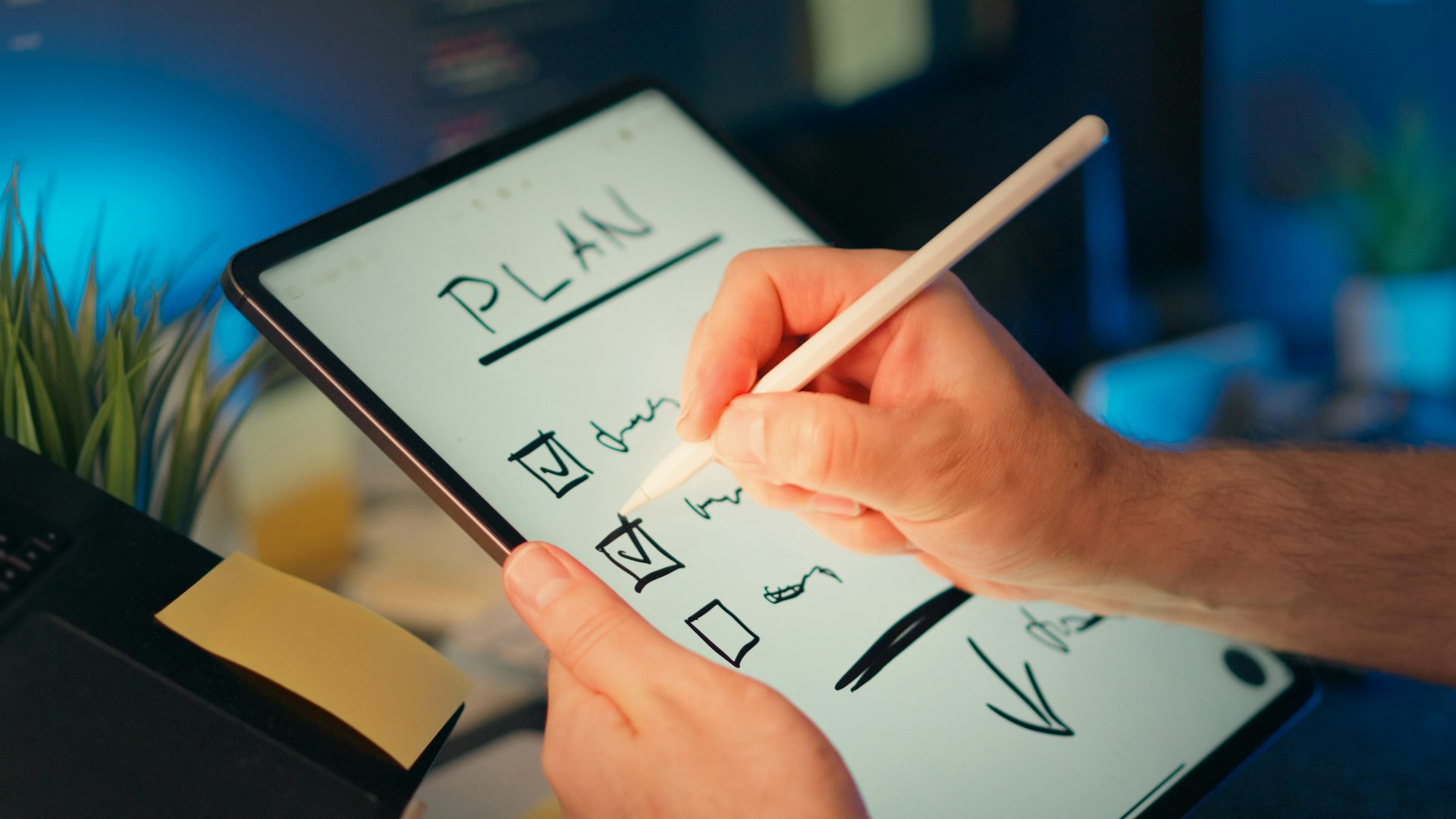 Someone is writing a plan on a tablet